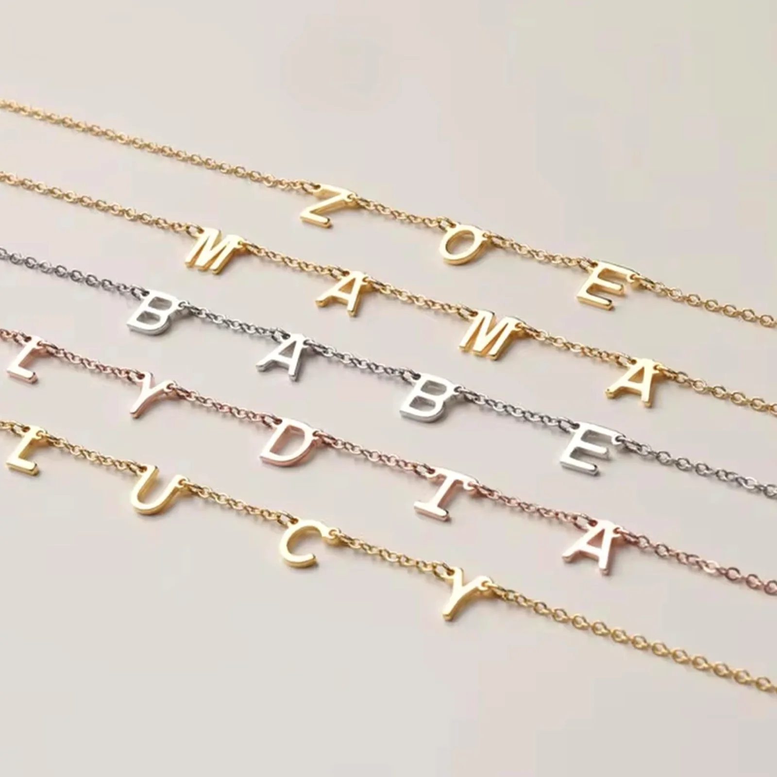 Four gold nameplates laid out one under another, each with a different name, showing how the letters join